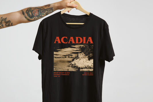 Black t-shirt with 'ACADIA' design on a hanger against a white background