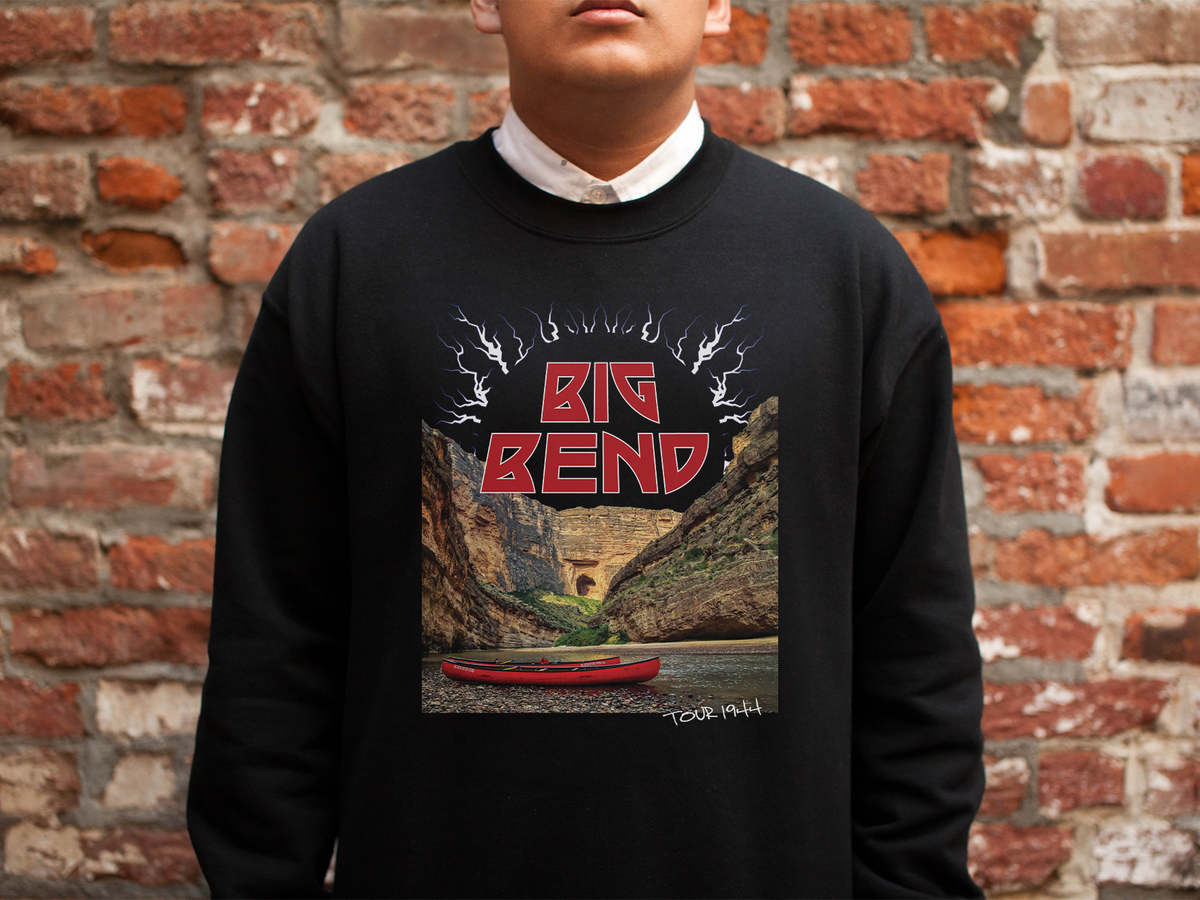 A person wearing a black sweatshirt with a 'Big Bend' graphic design, standing in front of a brick wall