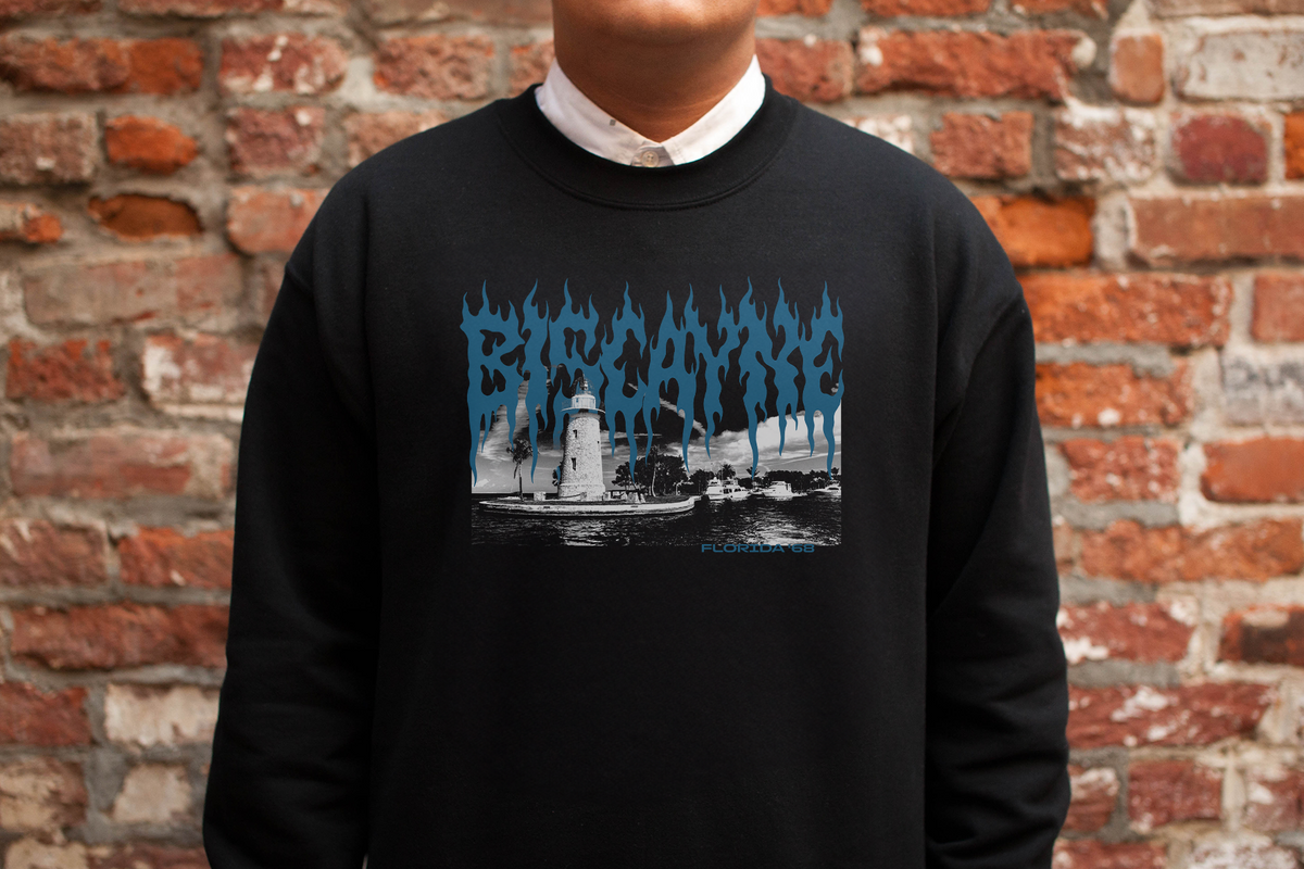 Person wearing a black sweatshirt with 'Biscayne' graphic design against a brick wall