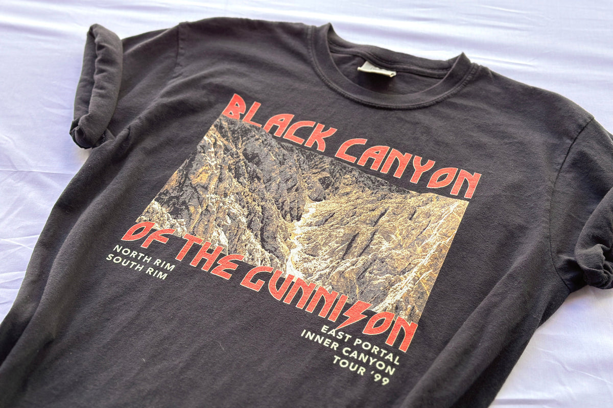 Black t-shirt with 'Black Canyon of the Gunnison' graphic design on a white surface