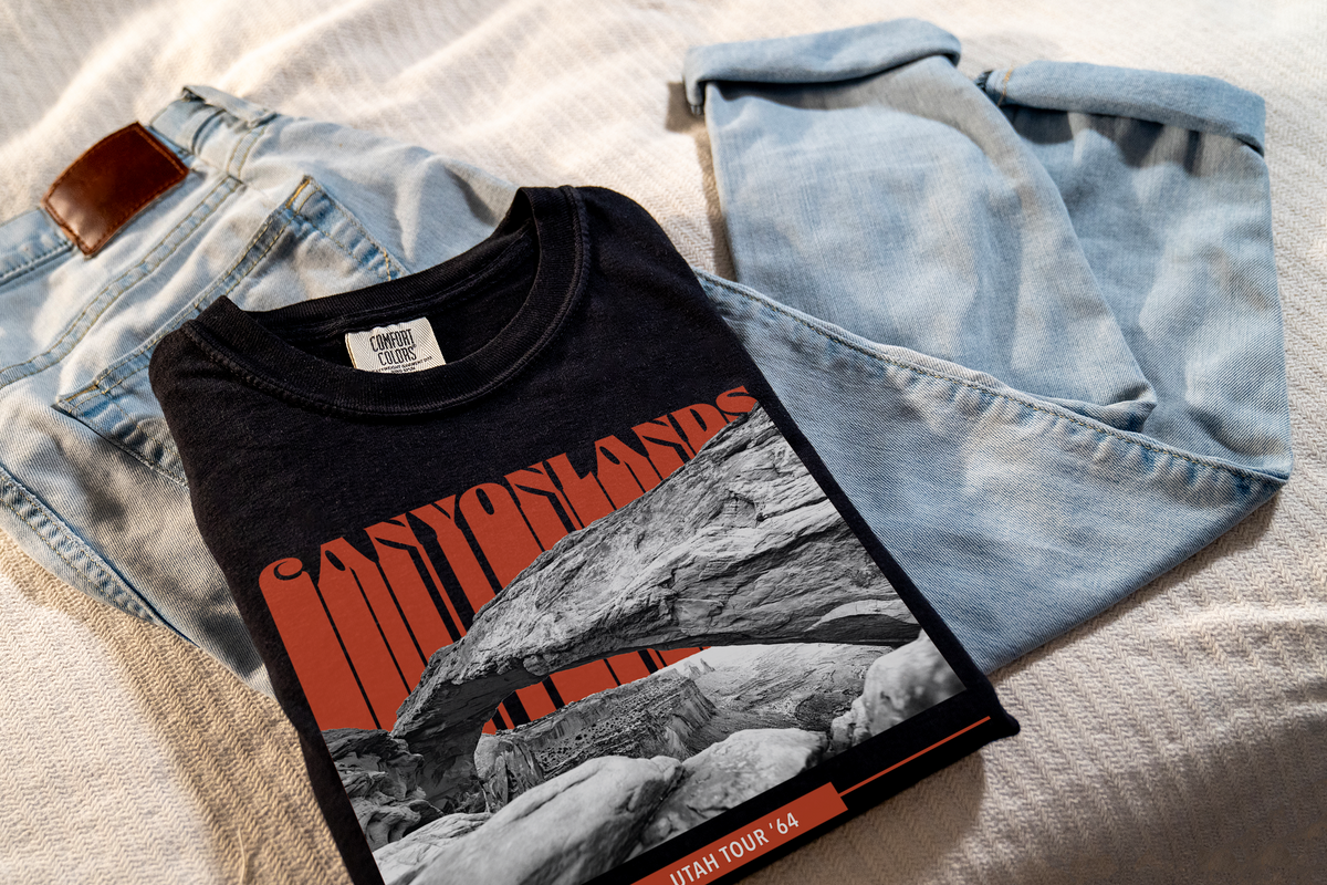 Black t-shirt with a 'Canyonlands' graphic design, laying on jeans