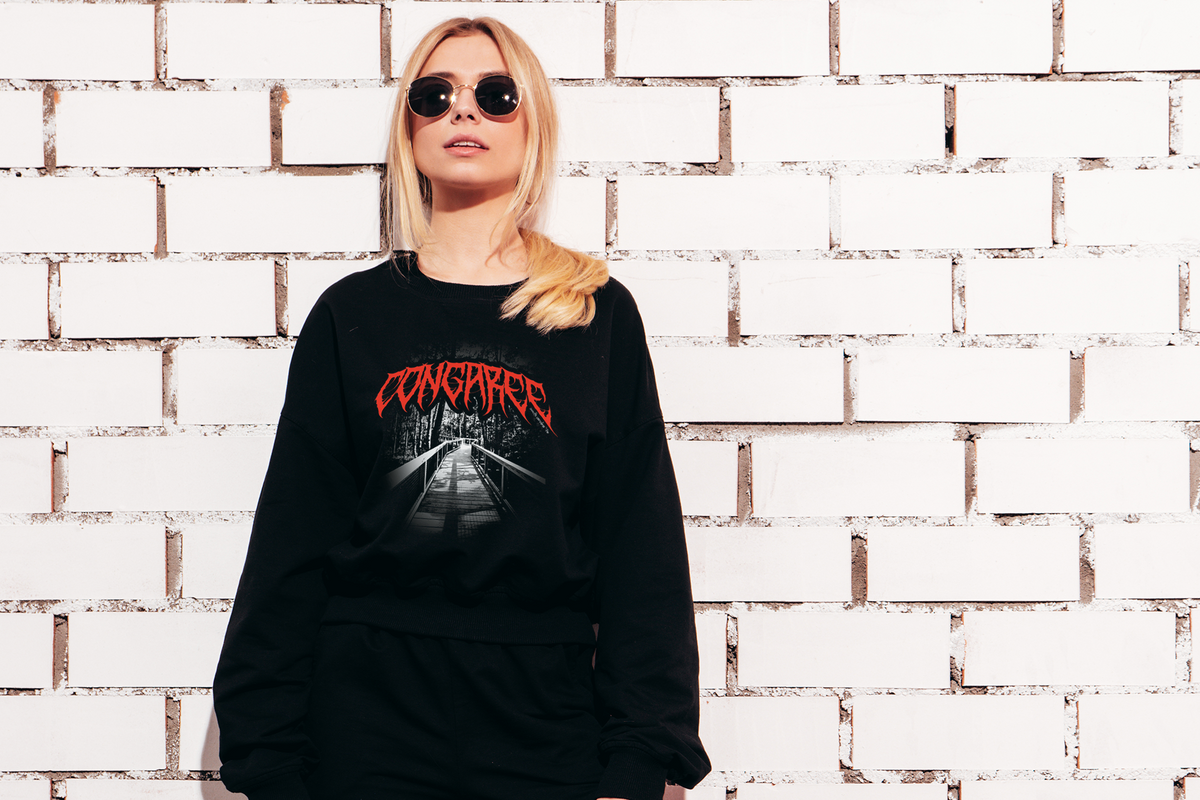Person wearing a black sweatshirt with red 'Congaree' text against a white brick wall
