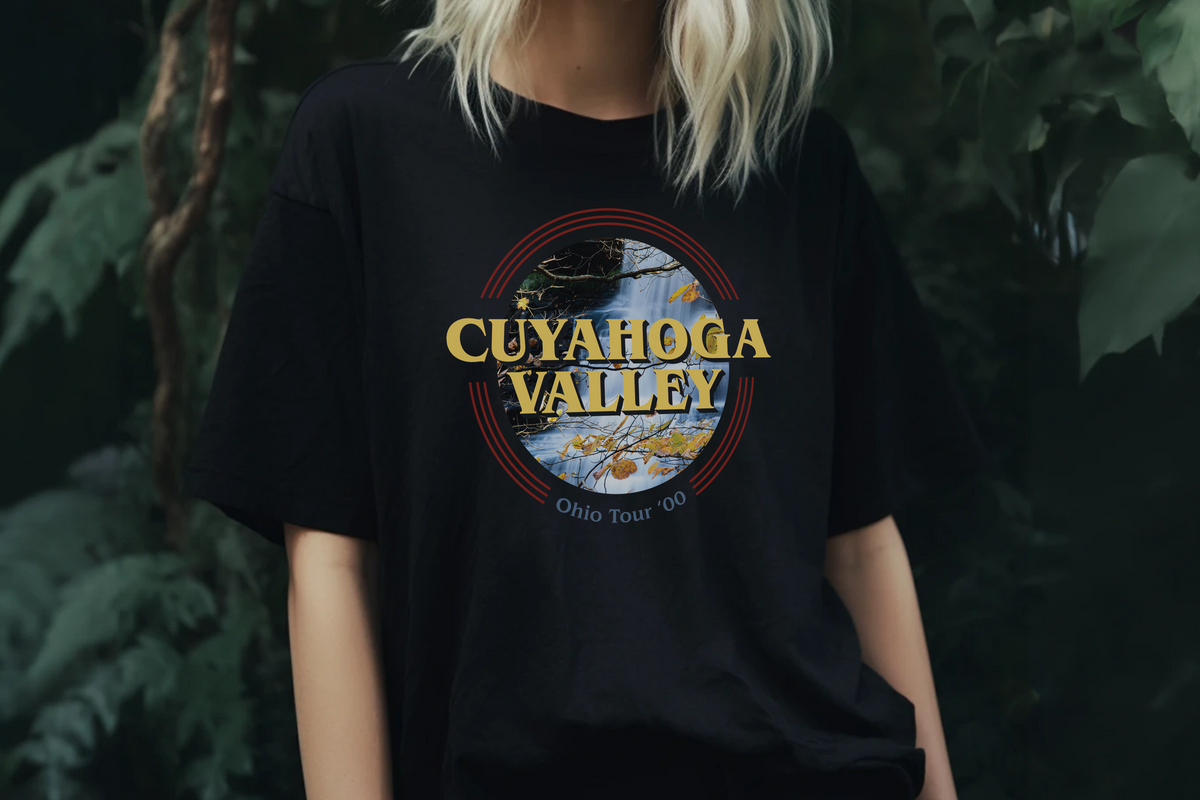 Person wearing a black t-shirt with 'Cuyahoga Valley' design against a dark background
