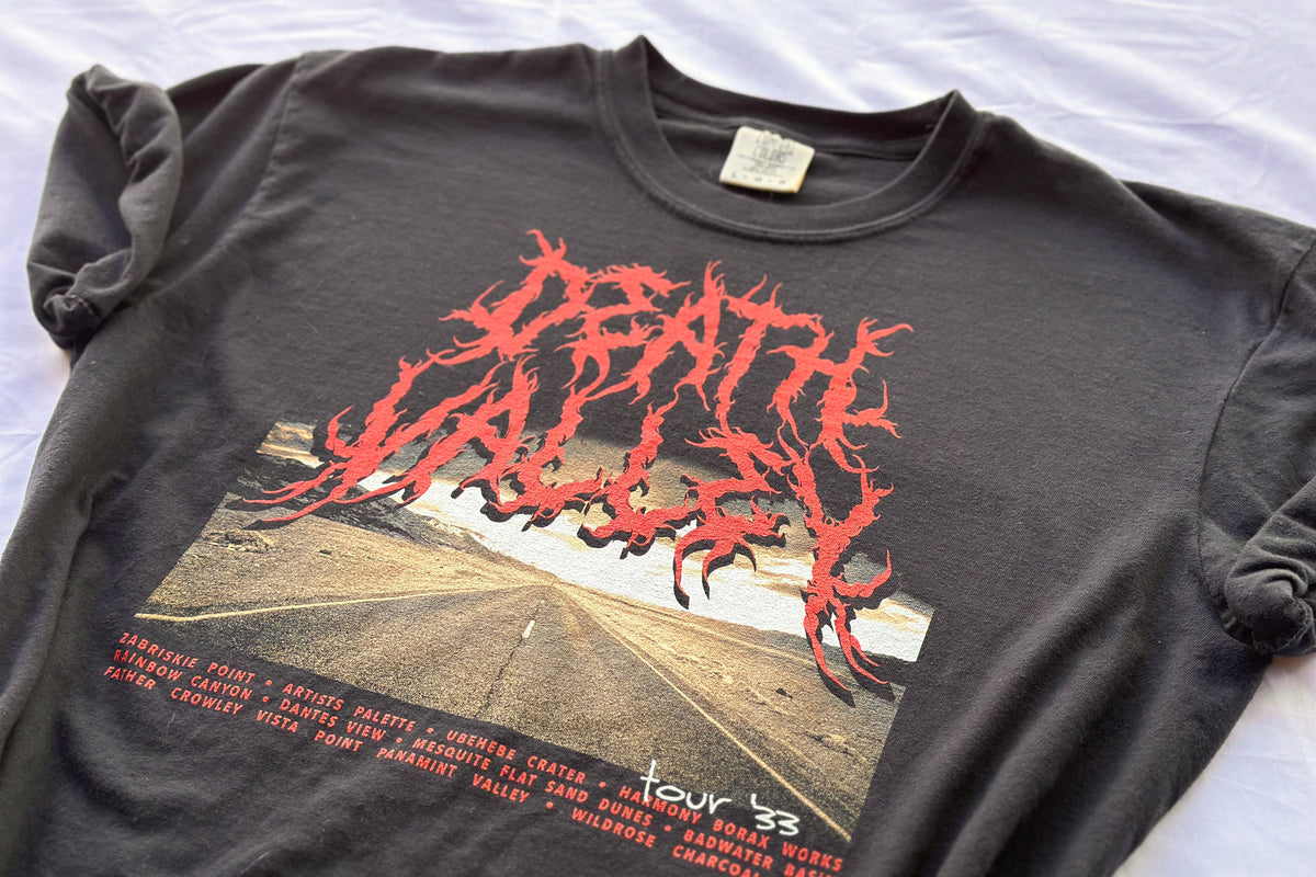 Black t-shirt with red graphic design on a white surface