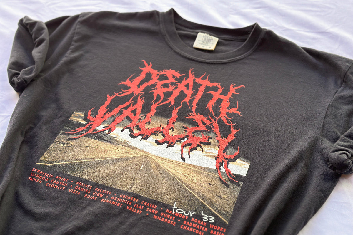 Black t-shirt with red graphic design on a white surface