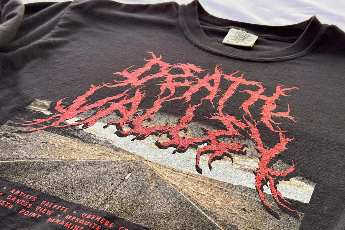 Black t-shirt with red graphic design and text on a road background