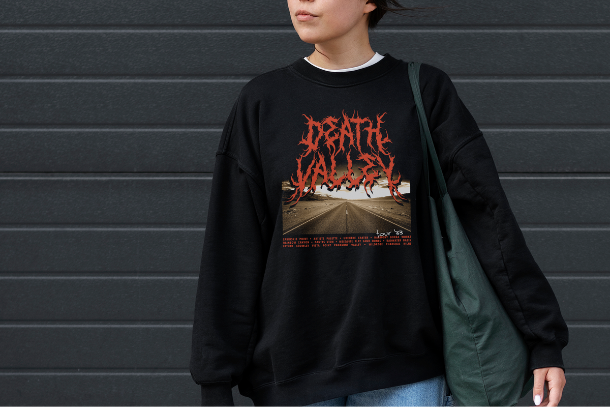 Person wearing a black sweatshirt with 'Death Valley' graphic design against a gray wall.