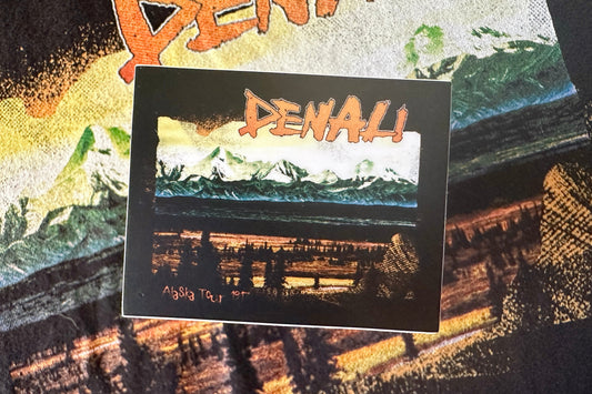Sticker with a 'Denali' graphic design, on a textured bcakground