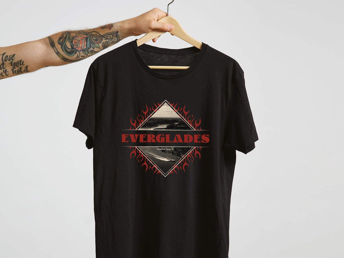 Black t-shirt with 'Everglades' graphic design on a hanger against a white background
