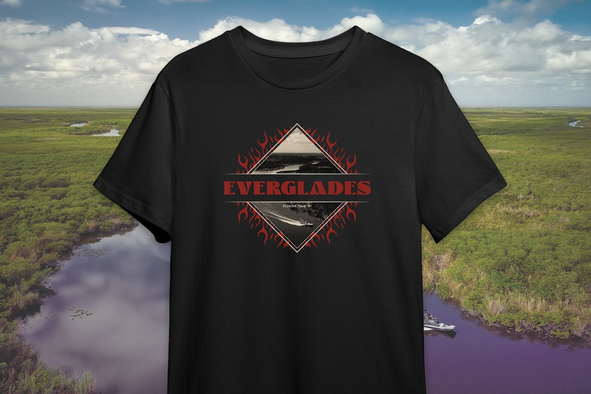 Black t-shirt with 'Everglades' graphic design against a scenic background of water and greenery