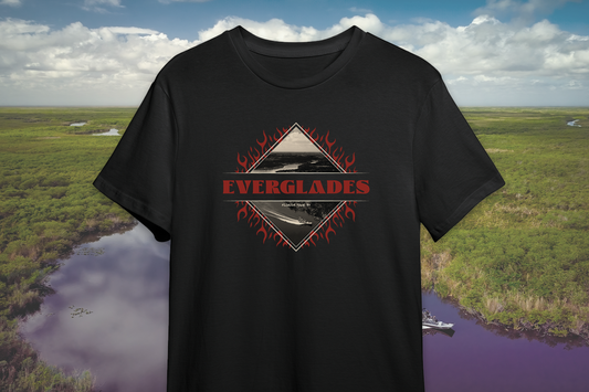 Black t-shirt with 'Everglades' graphic design against a scenic background of water and greenery