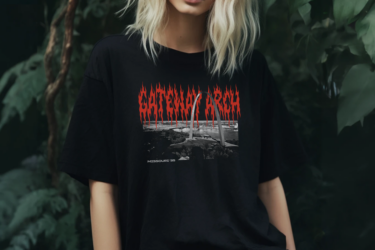 Person wearing a black t-shirt with 'Gateway Arch' design in red and white against a dark background