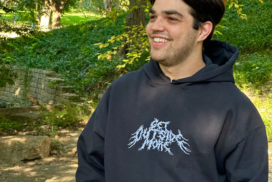 Person wearing a black hoodie with white text outdoors