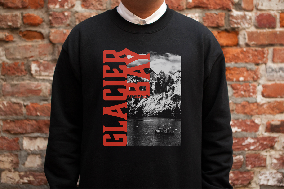 Person wearing a black sweatshirt with a 'Great Basin' graphic design and text against a brick wall.