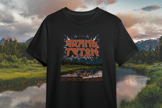 Black t-shirt with Grand Teton design against a scenic background of mountains and lake.