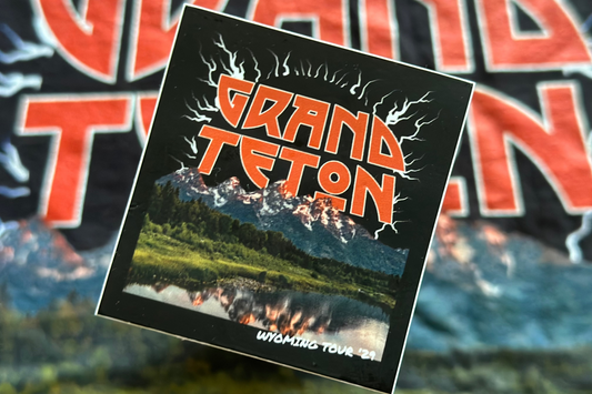 Sticker with 'Grand Teton' text and mountain graphic on a blurred background