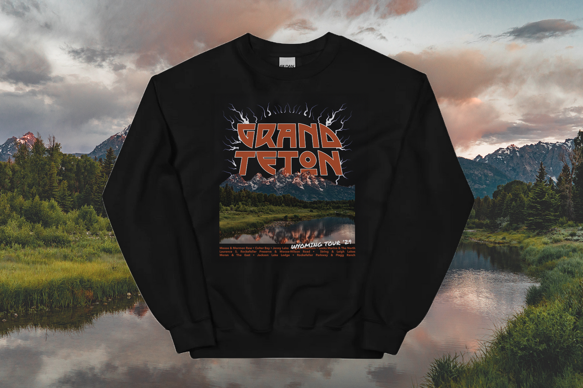 Black sweatshirt with 'Grand Teton' design against a scenic mountain backdrop