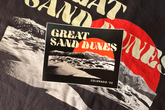 Sticker with 'Great Sand Dunes' design on a black background with desert graphic