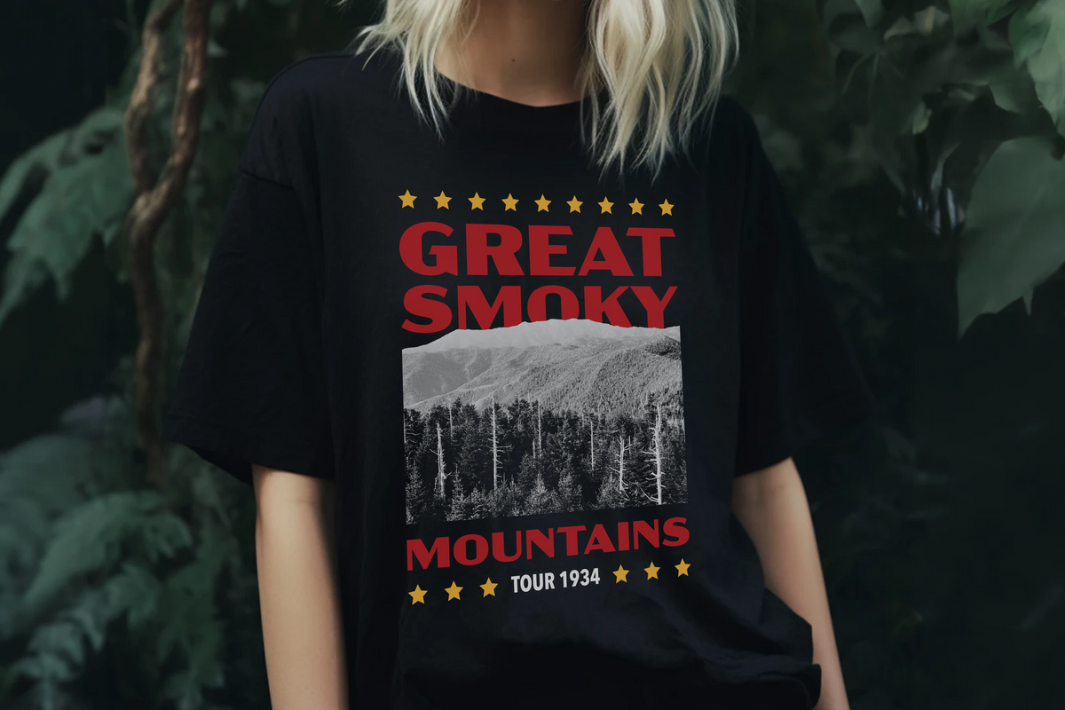 Person wearing a black t-shirt with 'Great Smoky Mountains' design against a dark background.