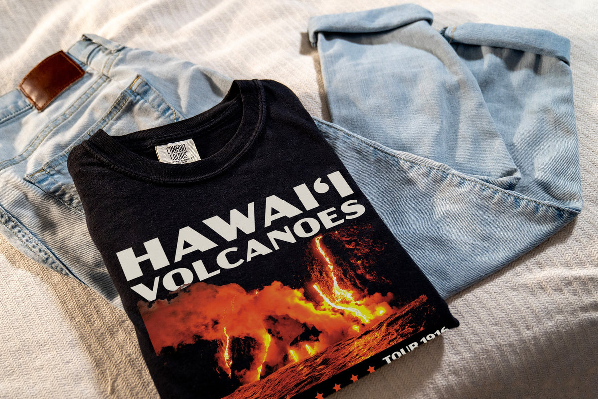 Black t-shirt with 'Hawaii Volcanoes' design, laying on jeans
