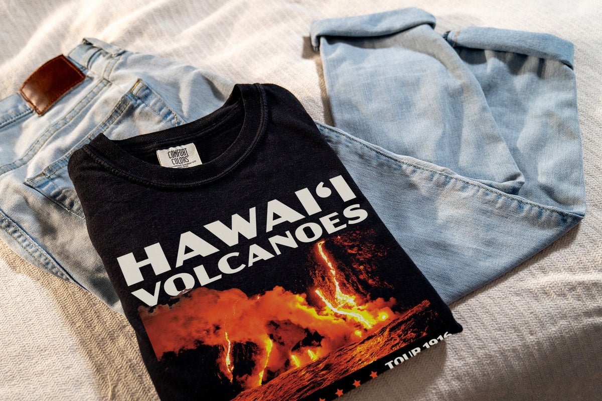 Black t-shirt with 'Hawaii Volcanoes' design, laying on jeans