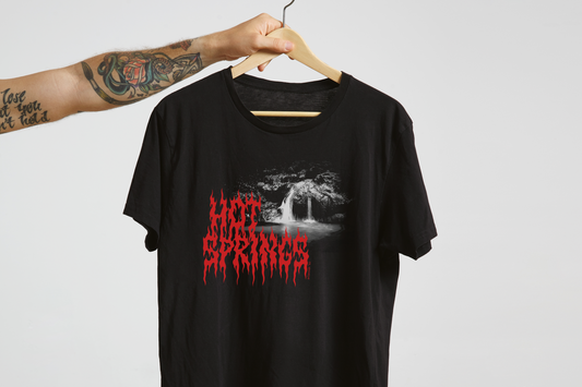 Black t-shirt with red 'Hot Springs' text and graphic design on a hanger against a light gray background
