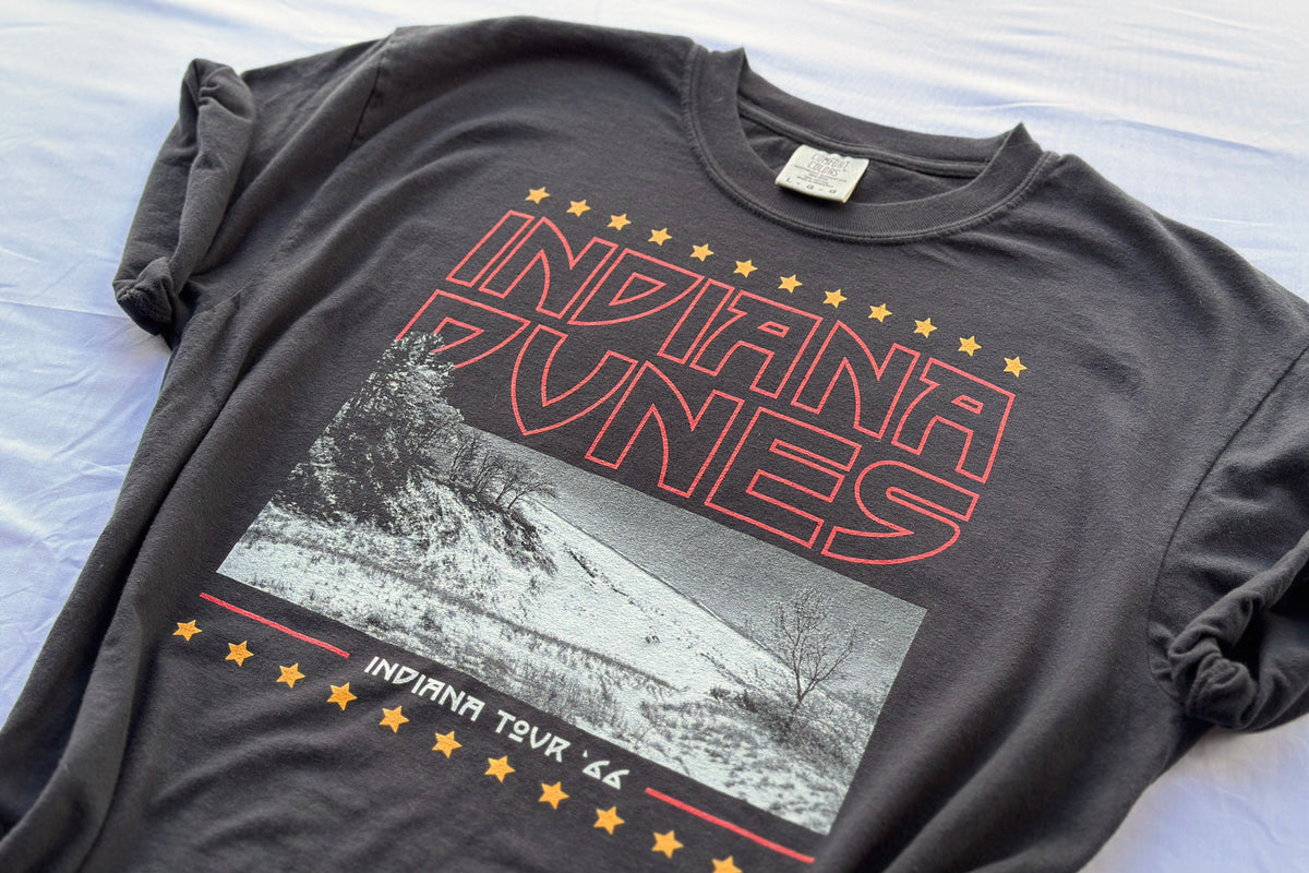 Black t-shirt with 'Indiana Dunes' graphic design on a white surface