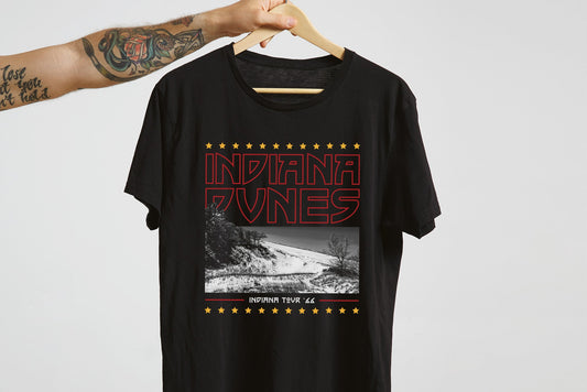 Black t-shirt with 'Indiana Dunes' graphic design on a hanger against a light gray background