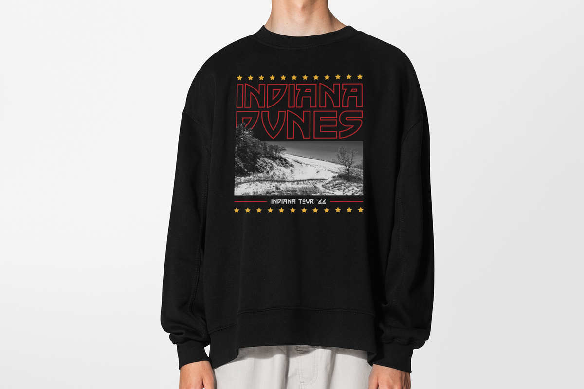 A person wearing a black sweatshirt with 'Indiana Dunes' graphic design, in front of a white background