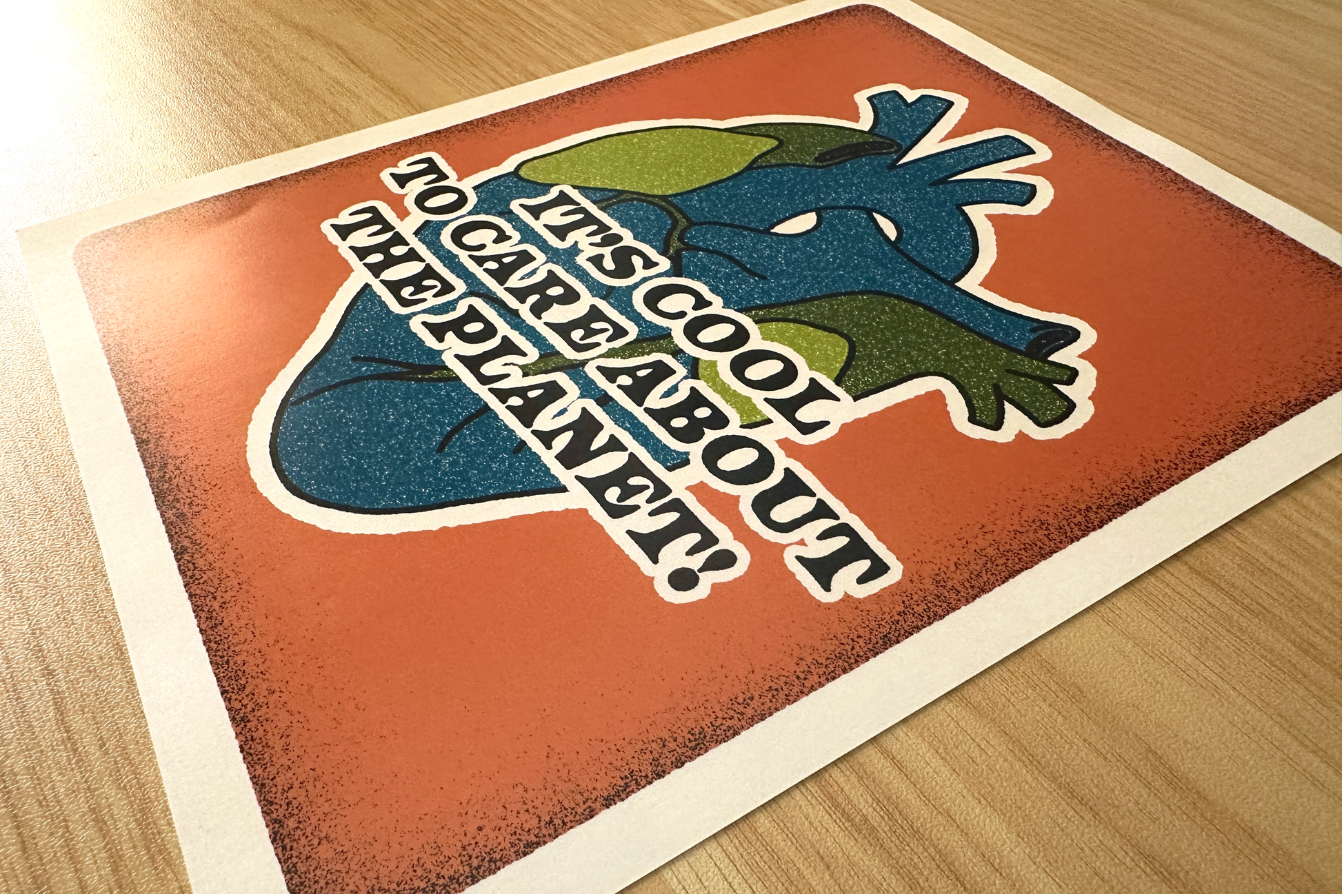 Art print with an illustration of a heart and text, placed on a wooden surface