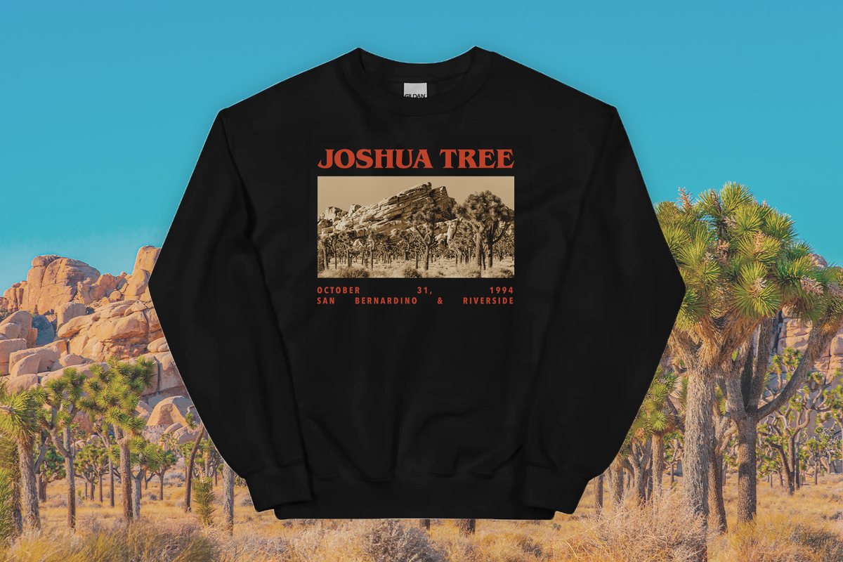 Black sweatshirt with Joshua Tree graphic against a desert landscape background