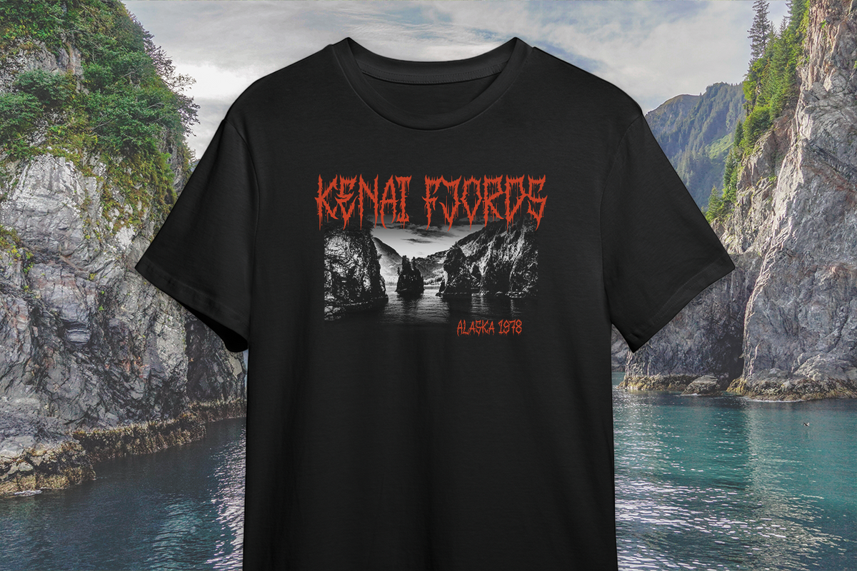 Black t-shirt with red and white 'Kenai Fjords' graphic design against a scenic mountain and water background