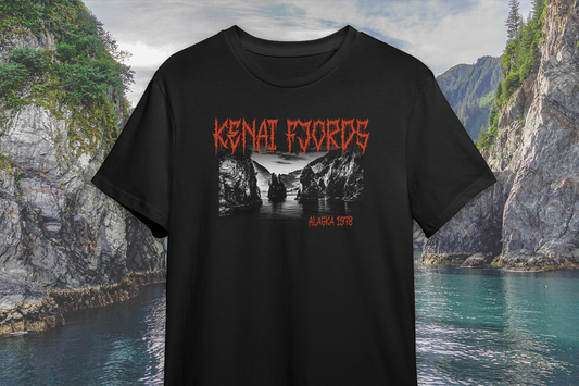 Black t-shirt with red and white 'Kenai Fjords' graphic design against a scenic mountain and water background