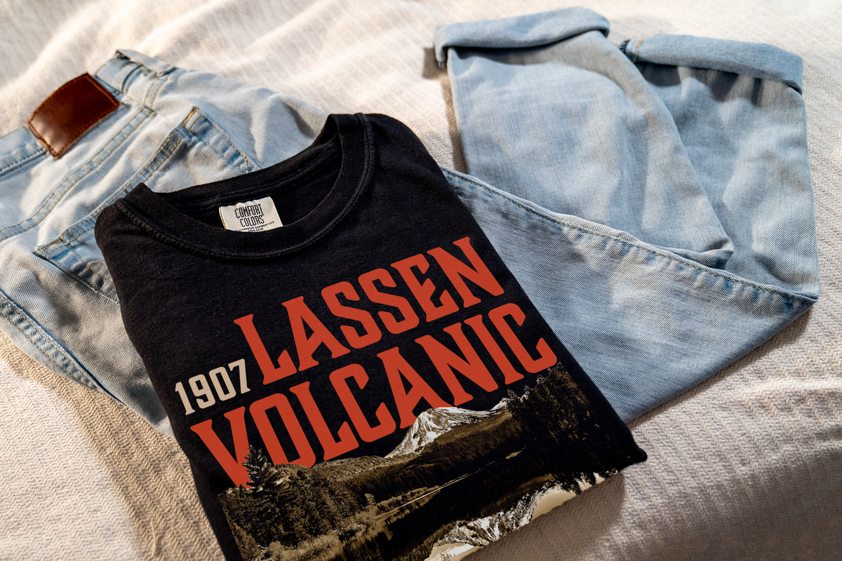 Black t-shirt with 'Lassen Volcanic' text and graphic on a light blue denim jacket.