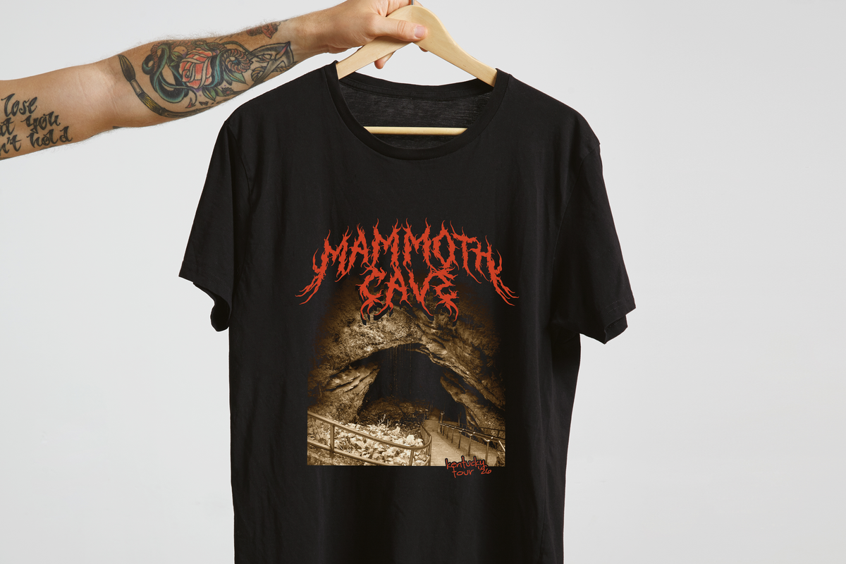 A black t-shirt with a 'Mammoth Cave' design, on a hanger in front of a white background