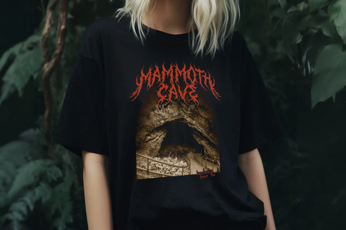 Person wearing a black t-shirt with 'Mammoth Cave' design against a dark background