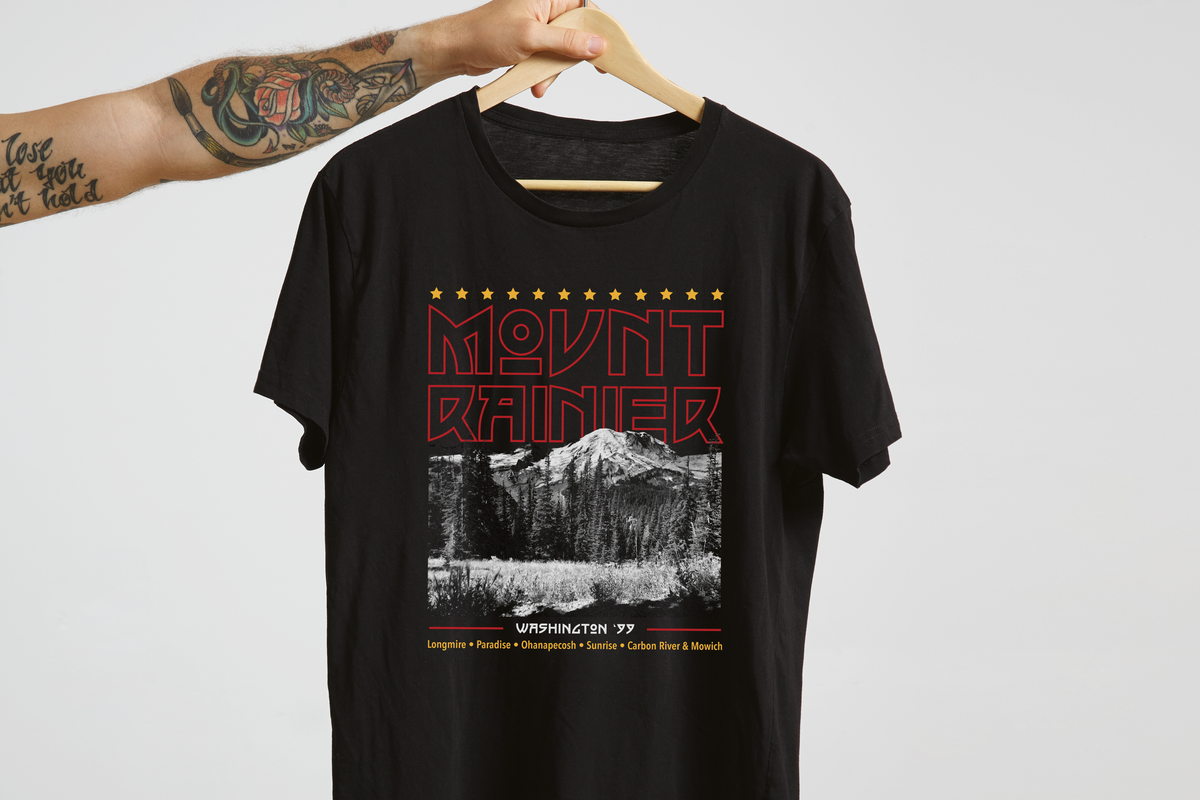 Black t-shirt with Mount Rainier design on a hanger against a white background