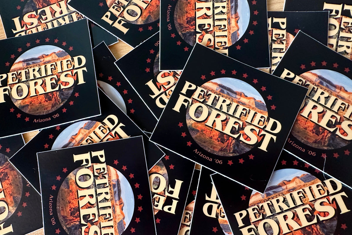 Multiple 'Petrified Forest' stickers with scenic design on a flat surface.
