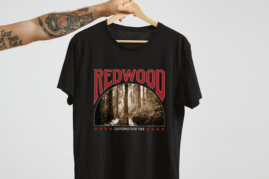 Black t-shirt with 'Redwood California Tour 1968' graphic design on a hanger against a light gray background.