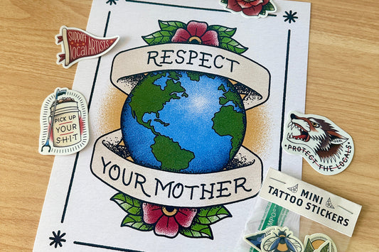 Art print with 'Respect Your Mother' design and other stickers on a wooden surface