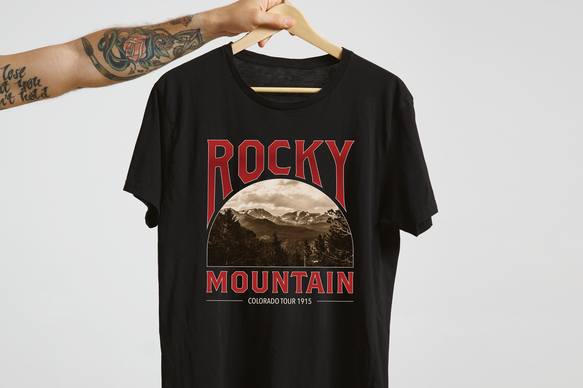 Black t-shirt with 'Rocky Mountain' graphic design on a hanger against a white background