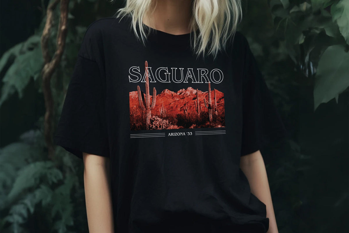 Person wearing a black t-shirt with 'Saguaro' design against a dark background