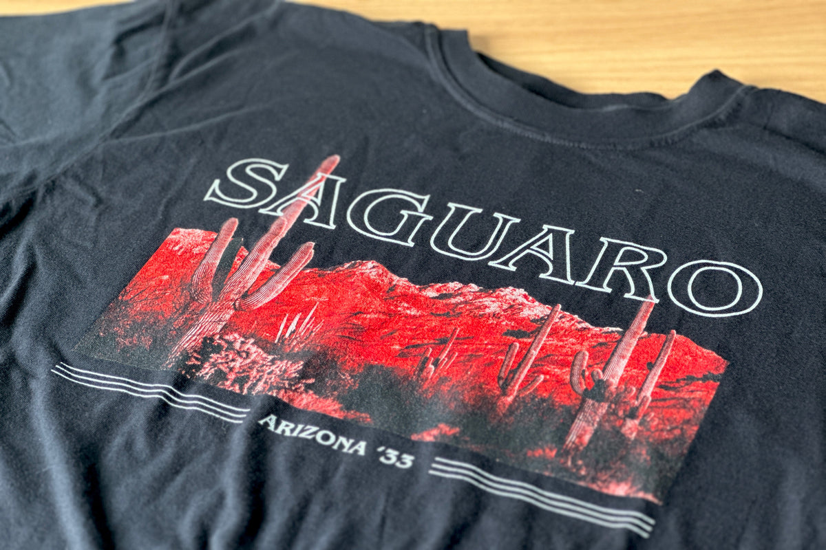 Black t-shirt with 'Saguaro' graphic design on a wooden surface