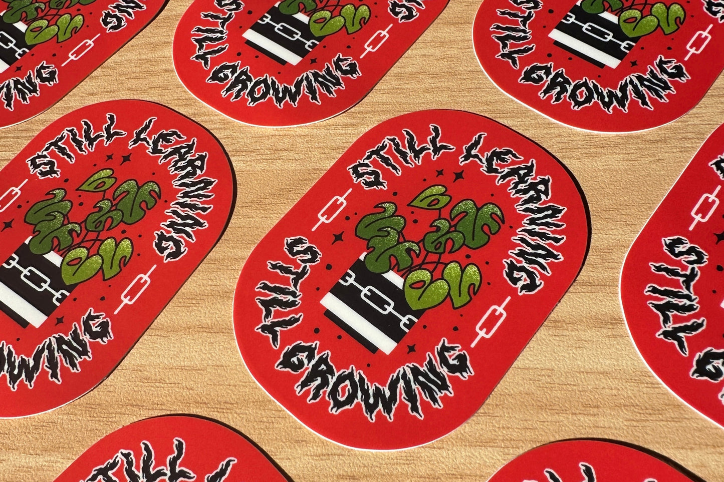Red and black stickers with text and illustration on a wooden surface