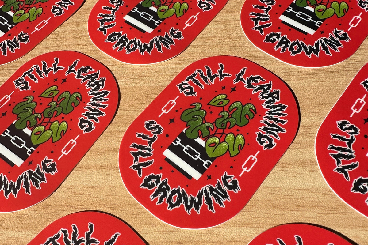 Red and black stickers with text and illustration on a wooden surface
