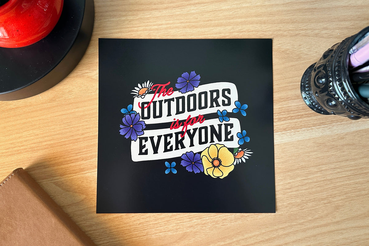 Art print with colorful text and flowers on a wooden surface
