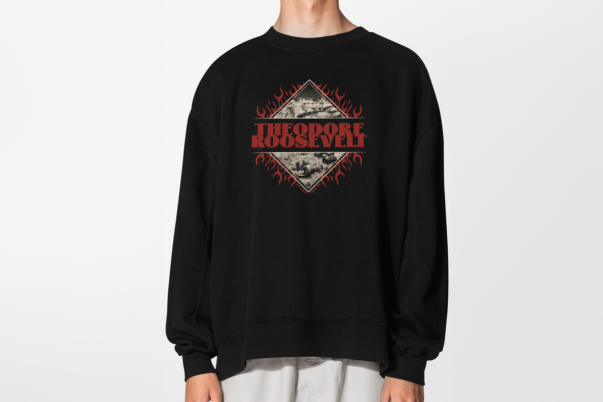 Person wearing a black sweatshirt with 'Theodore Roosevelt' graphic design in front of a white background