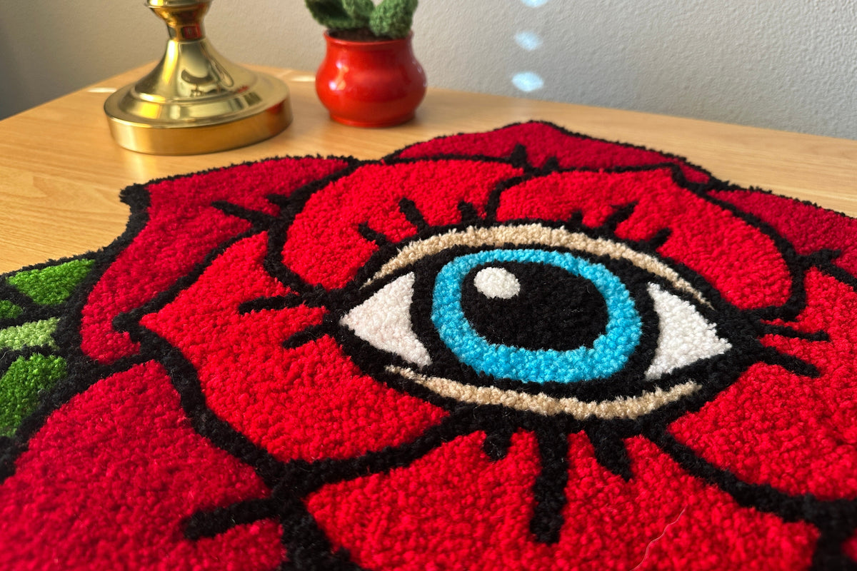 Tufted red rose with an eye design on a table