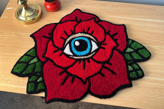 Tufted ed rose with an eye design on a wooden surface
