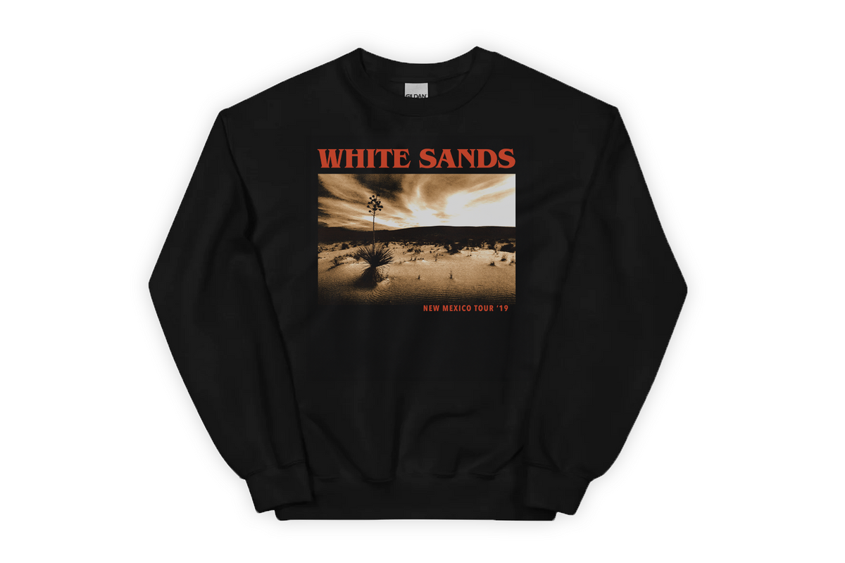 Black sweatshirt with a graphic design of a desert landscape and 'White Sands' on a white background